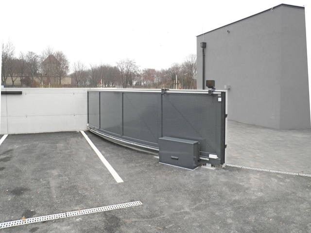 gebogenes Schiebetor mit Lochblechfüllung und Antriebsbox